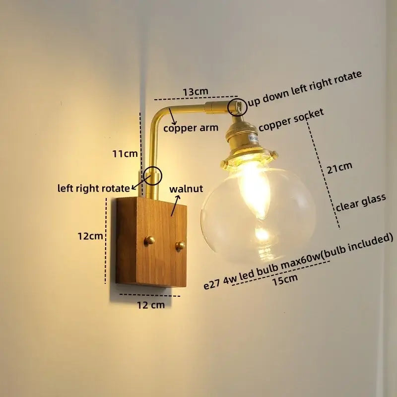 Modern etched glass copper led wall lights featuring a brass copper arm and clear glass globe on walnut wood base
