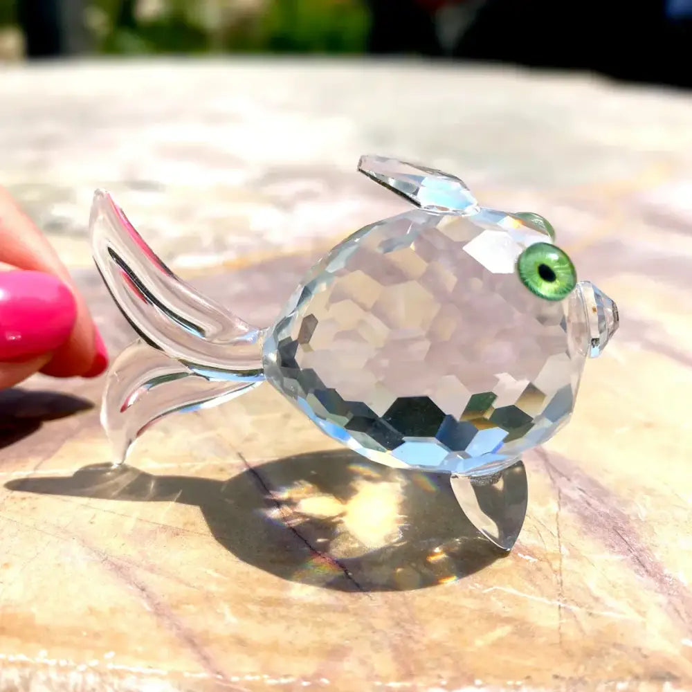 A sparkling clear faceted glass goldfish glass miniature sculpture with vibrant green eye for modern living room decorbites