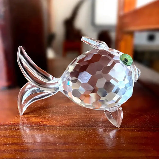 A clear faceted crystal goldfish glass miniature sculpture with a vibrant green eye for modern living room decor