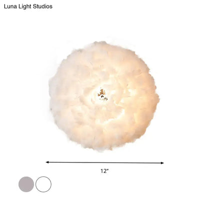 Modern feather material wall light in grey and white with a soft fluffy feather pendant and warm glow for bedroom use