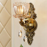 Modern floral brass wall sconce with gold tone, amber glass shade, and teardrop crystal drop for living room lighting