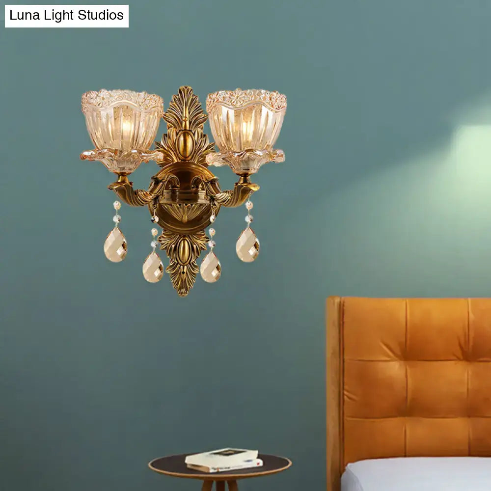Modern floral brass two-light wall sconce with teardrop crystal drop and amber glass shades for living room lighting