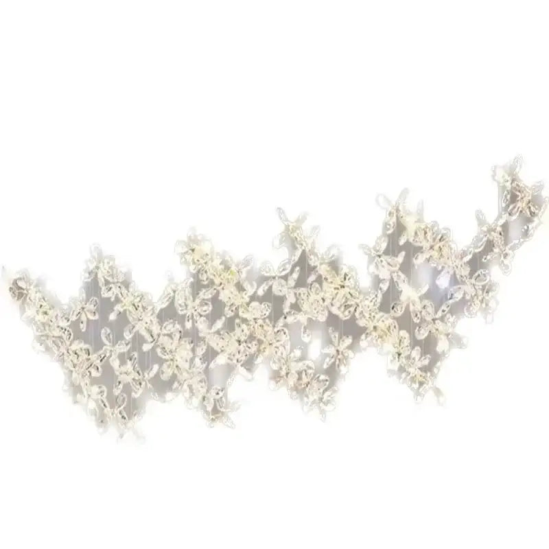 A cream-colored lace headband with floral patterns and embellishments featured with decorbites crystal led chandelier