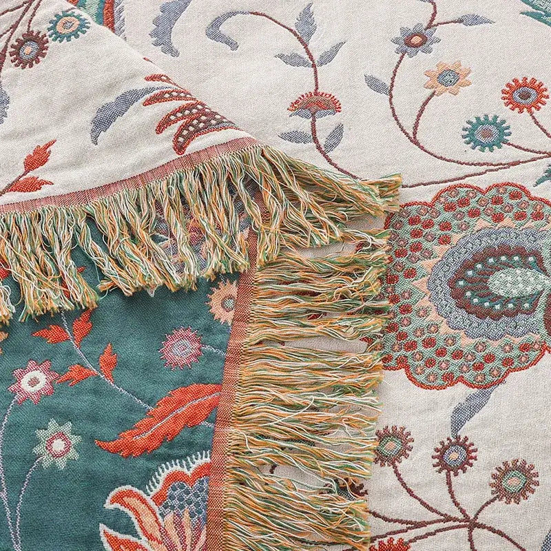 A cozy decorbites cooling cotton blanket with vibrant teal coral floral pattern and multicolored fringe on cream background
