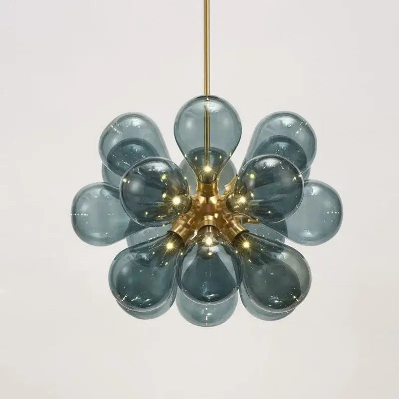 A modern teal glass ball pendant light with brass hub and floral design ideal for dining room decorbites decor