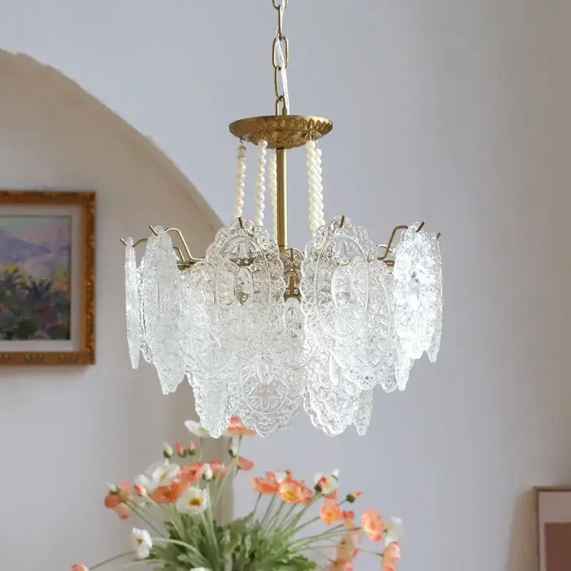 Modern french gold and clear glass led chandelier featuring intricate lace-like cutouts and brass-finished frame for decorbites clear glass lighting