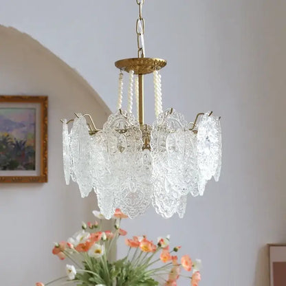 Modern french gold and clear glass led chandelier featuring intricate lace-like cutouts and brass-finished frame for decorbites clear glass lighting