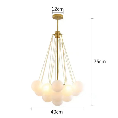 Gold-toned modern pendant lights with multiple frosted glass ball shades suspended by thin metallic cords for dining room