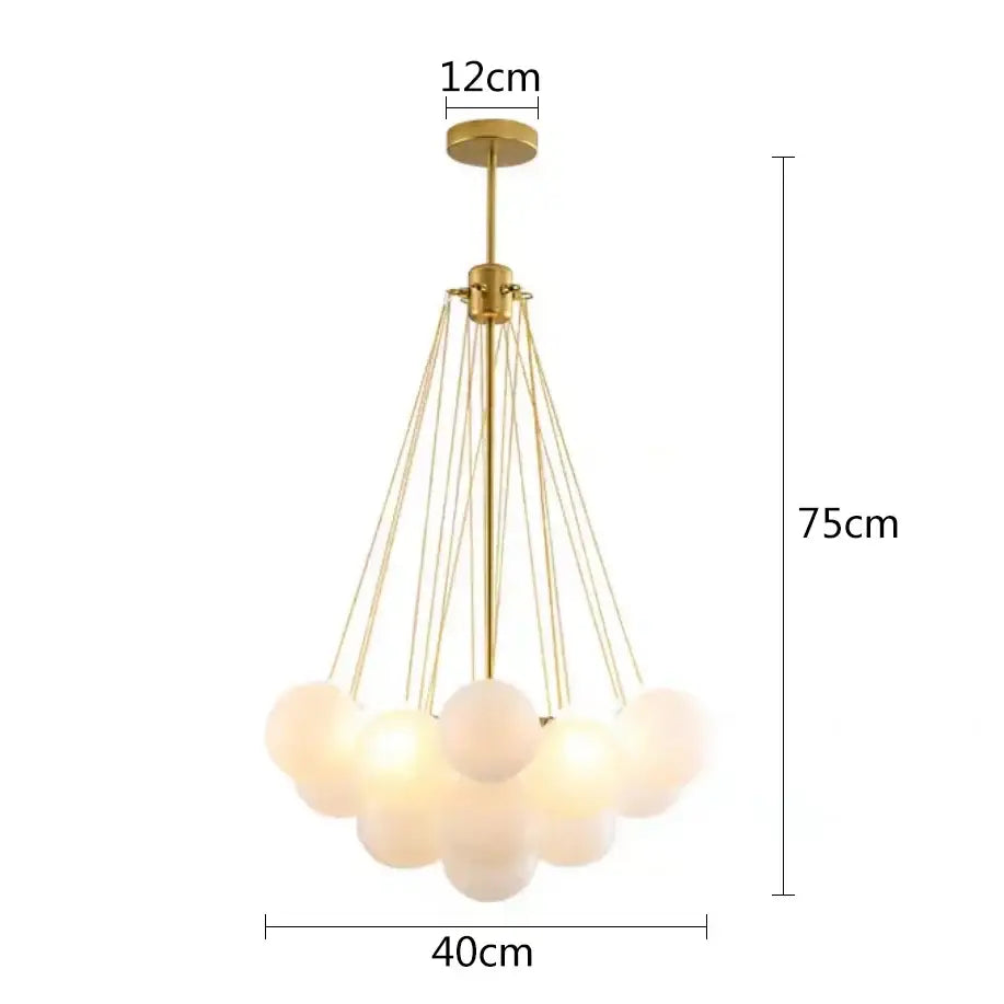 Gold-toned modern pendant lights with multiple frosted glass ball shades suspended by thin metallic cords for dining room