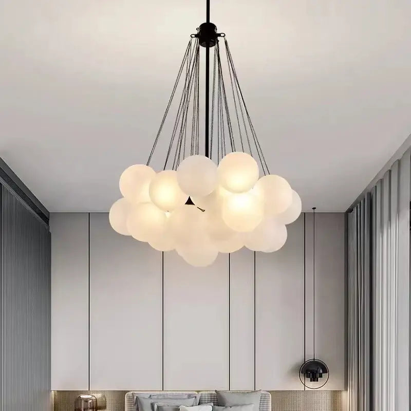 Modern pendant lights featuring frosted glass ball globes shaped like clouds suspended by black chains for dining room use