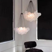Modern frosted glass ball cloud pendant lights with translucent frosted glass spheres and dark metal chains for dining room
