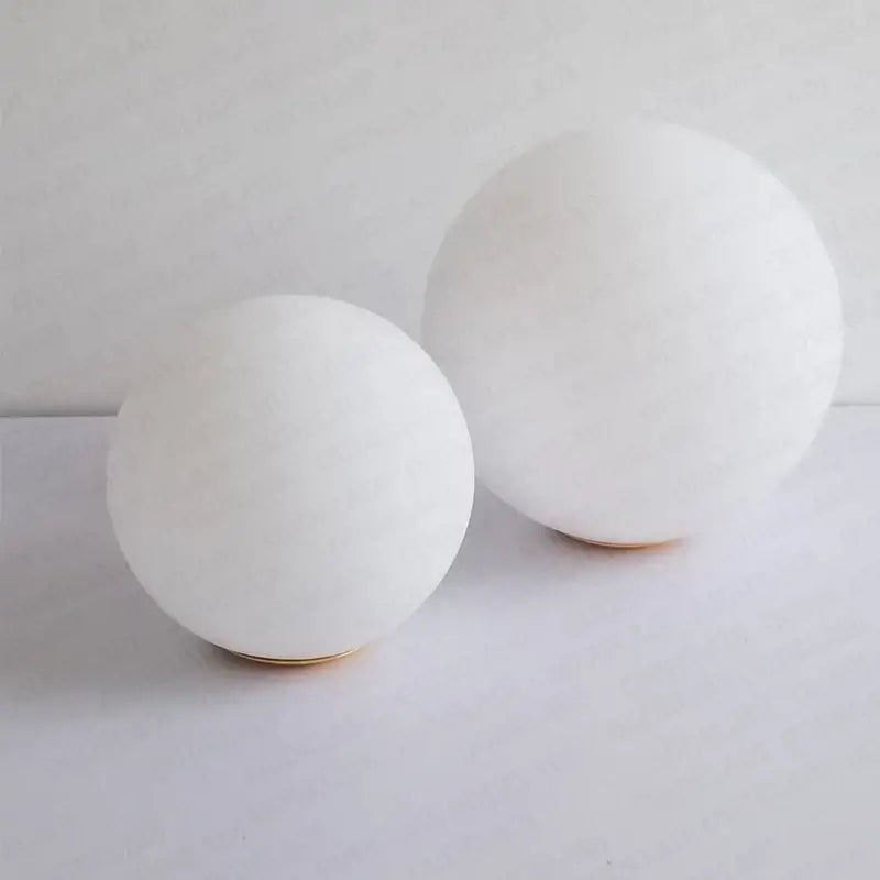 Two minimalist white frosted glass ball pendant lamps with smooth matte finish and gold ring bases for bedroom decorbites glass ball