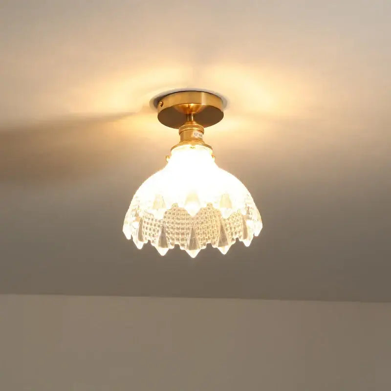 A modern frosted glass led ceiling light with brass finish and intricate cutwork flower design for corridor use