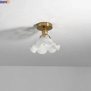 A delicate white frosted glass led ceiling light with ruffled flower design and polished brass mounting fixture