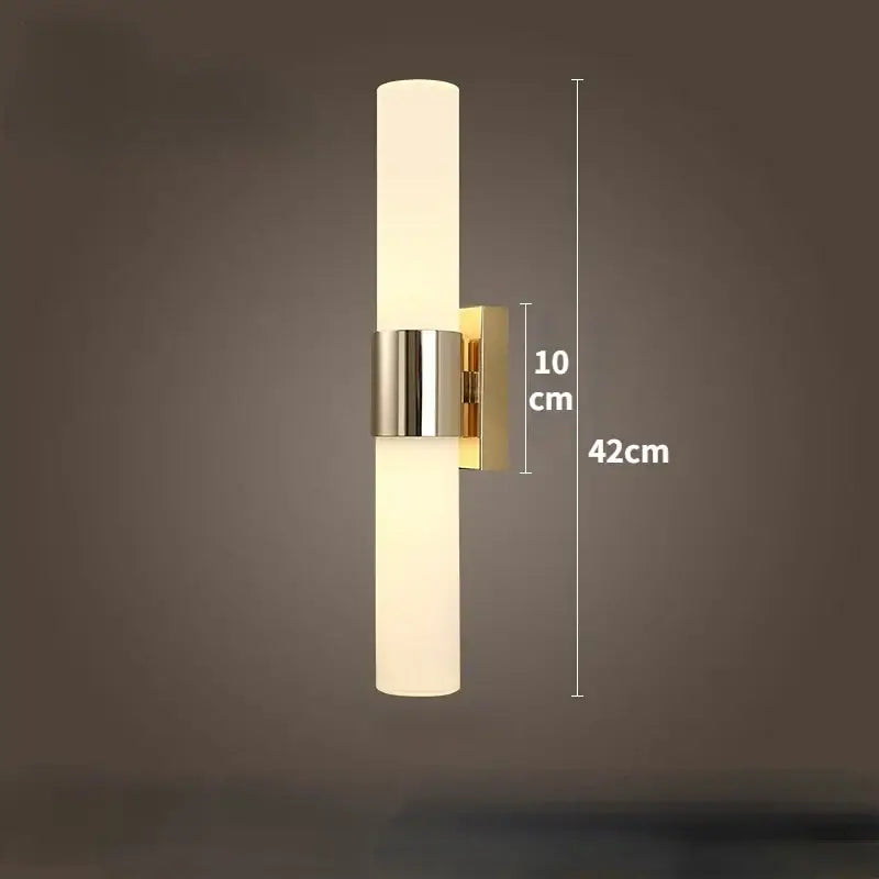 Modern gold-toned led wall lamp with frosted glass cylinder and polished metal accents for bedroom use