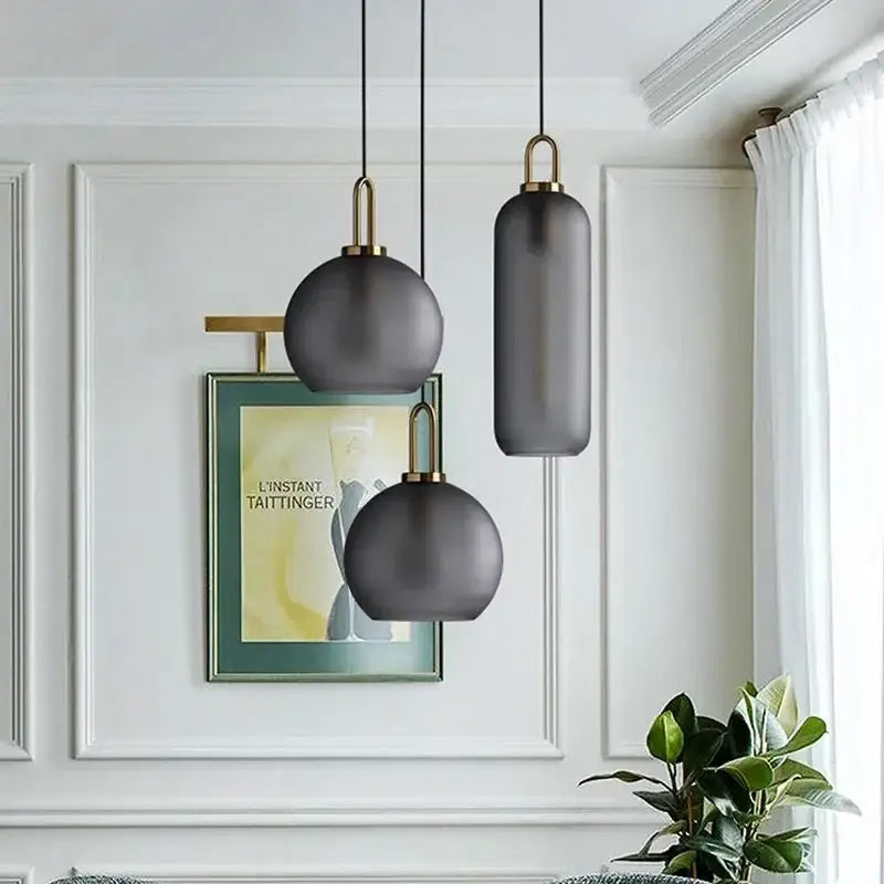 Modern frosted gray glass ball pendant light with brass accents for kitchen lighting featuring decorbites glass ball design