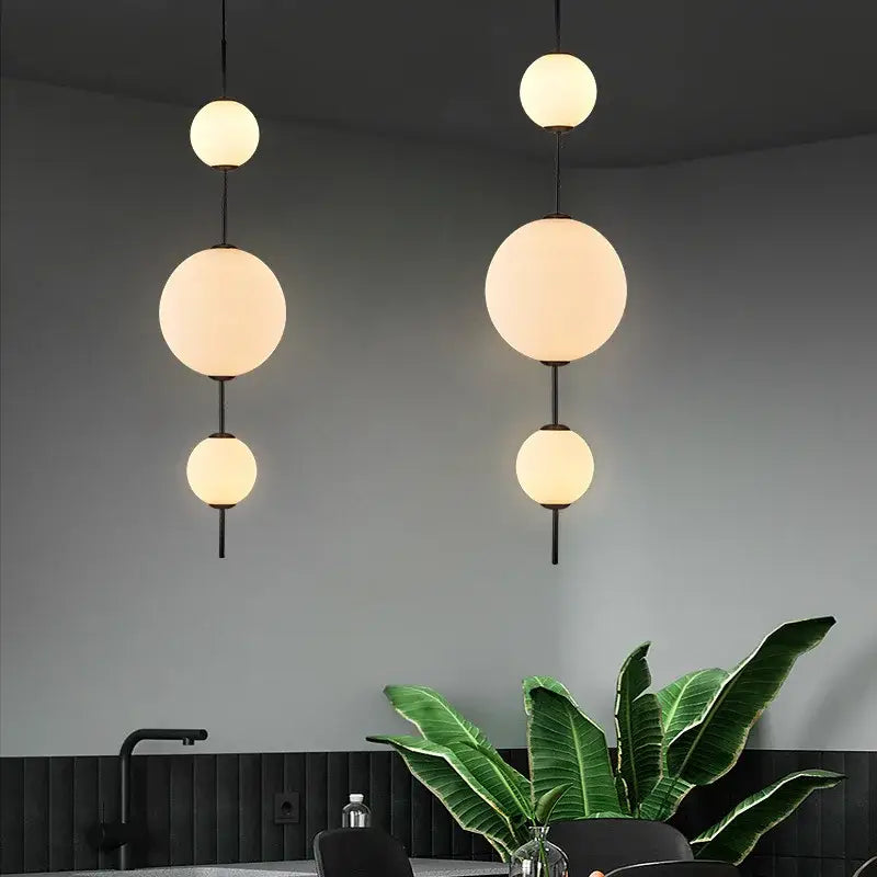Modern pendant lamp with white glass ball shades and black metal fixtures ideal for dining room lighting
