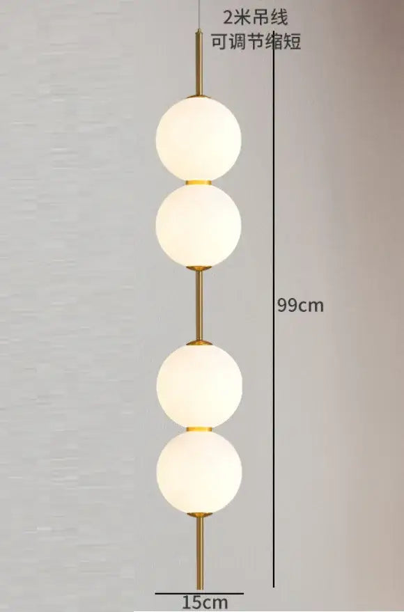 Gold-toned pendant lamp with four frosted white glass ball globes stacked vertically for dining room lighting