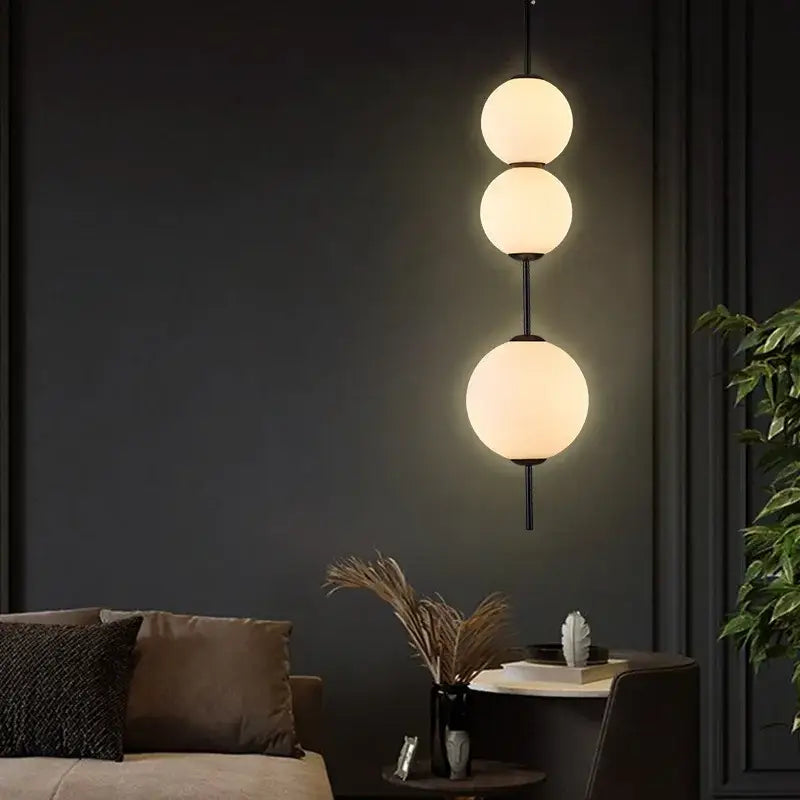 Modern three-tiered pendant lamp with frosted white glass balls and black metal rods for dining room lighting