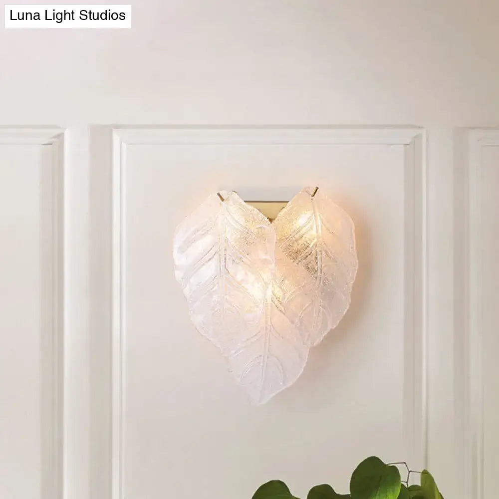 Modern frosted white glass leaf wall sconce light with translucent overlapping leaves and subtle veining details