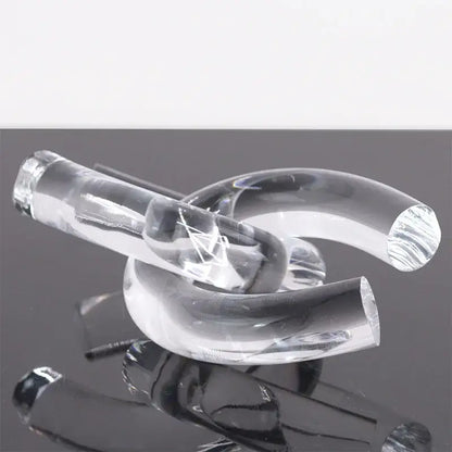 Clear transparent glass pipe with smooth curves and polished ends in modern geometric acrylic rope knot home decor sculpture