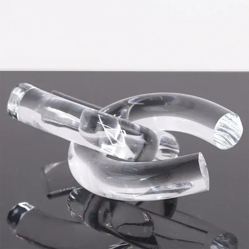Clear transparent glass pipe with smooth curves and polished ends in modern geometric acrylic rope knot home decor sculpture