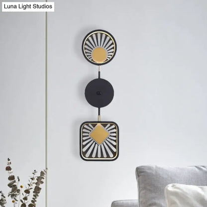 Modern geometric black and gold wall lamp with sunburst design and three stacked circular elements for living room use