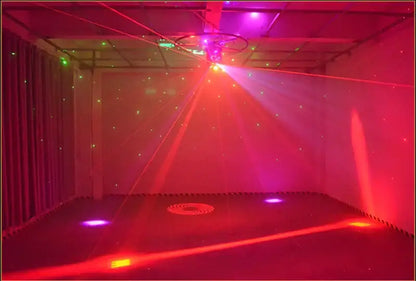 A modern geometric black light bar strobe projecting vibrant red and purple laser beams in a dimly lit room