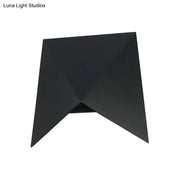 Modern geometric black metal wall sconce with angular faceted design ideal as bedroom wall lamp or metal wall sconce