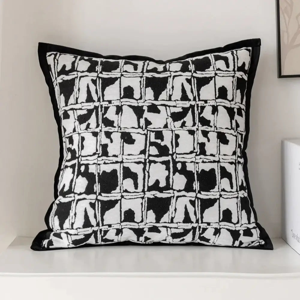 Modern geometric black and white embroidered pillow cover with bold grid pattern for living room decor