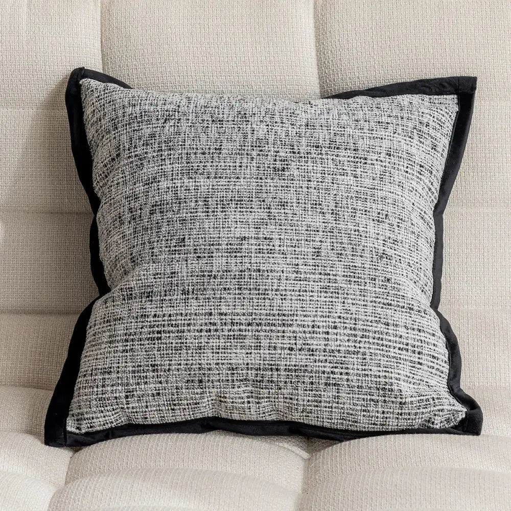 Modern geometric black and white embroidered pillow cover with textured tweed fabric and black velvet trim for living room