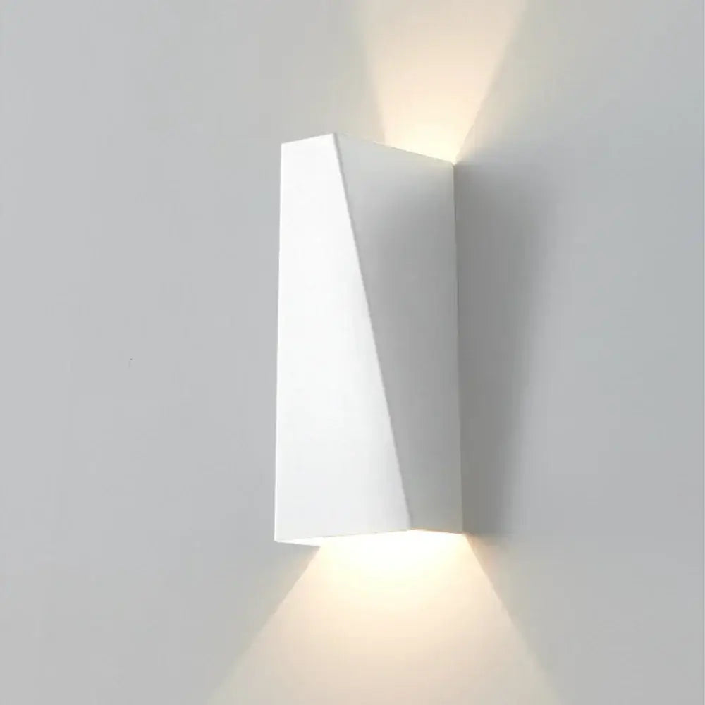 Modern geometric black and white led wall light with angular minimalist design casting warm light for living room decorbites led wall