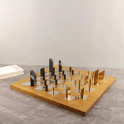 Modern geometric block chess set with a wooden board and gold and black metallic pieces for decorbites living room decor