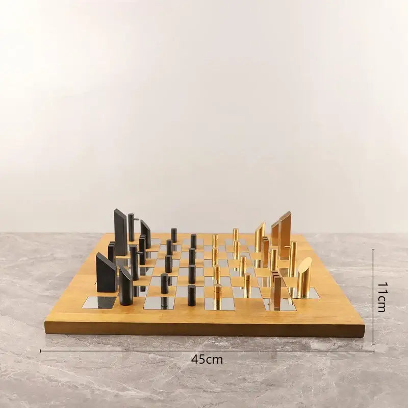 Modern geometric block chess set with sleek black and gold metallic pieces on light wood mirrored board for decorbites decor