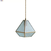 Modern geometric blue glass and brass pendant light with frosted panels suspended by a twisted gold cord for dining room decorbites blue glass