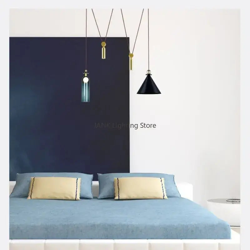 Modern geometric brass and black glass pendant light with gold fixtures and teal glass shades above the bed
