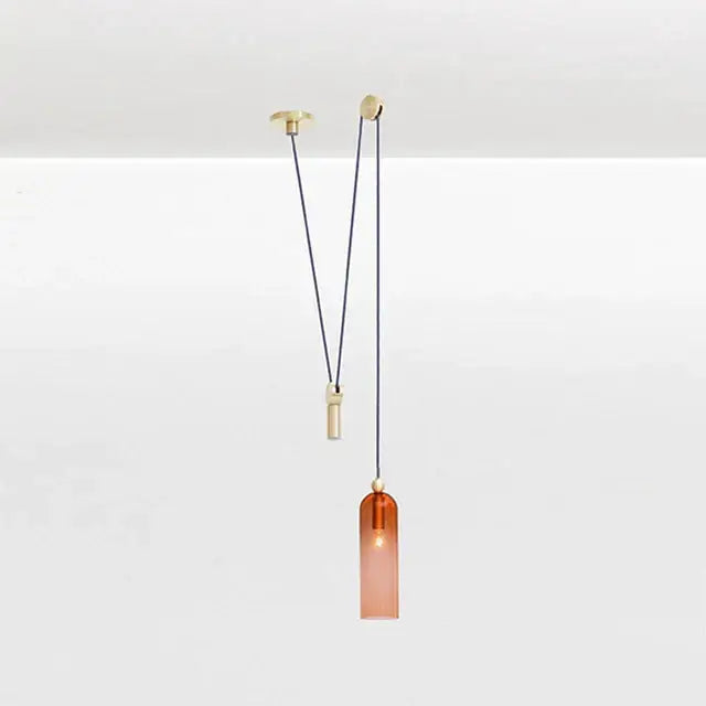 A sleek amber glass pendant light with brass-finished metal fixture ideal as a modern geometric glass chandelier