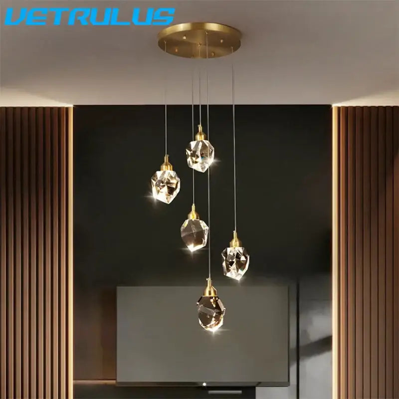 A modern geometric brass diamond crystal led chandelier with five faceted crystal droplets pendant light fixture
