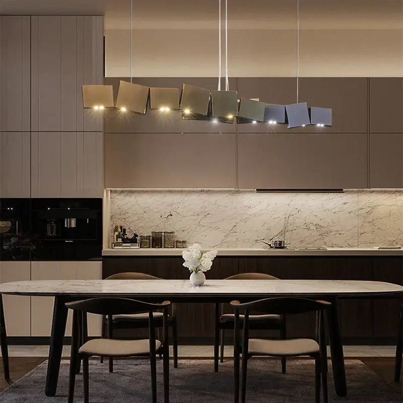 Modern geometric bronze and dark gray box shape pendant light with matte metallic finish above dining table decorbites