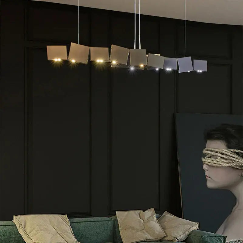Modern geometric bronze and dark gray box shape pendant light with matte metal shades in a linear dining room design