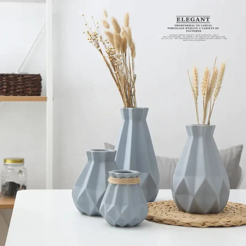 Set of four gray decorbites ceramic diamond vases with faceted geometric design holding dried grasses for living room decor