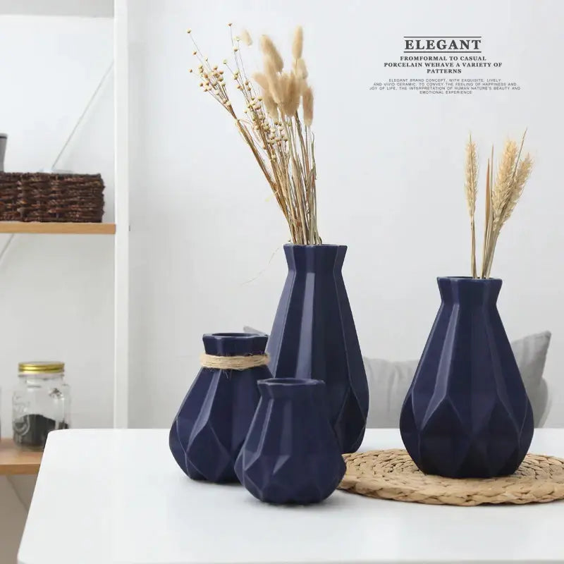 Set of four navy blue decorbites ceramic diamond vases with faceted surfaces and dried pampas grass arrangements