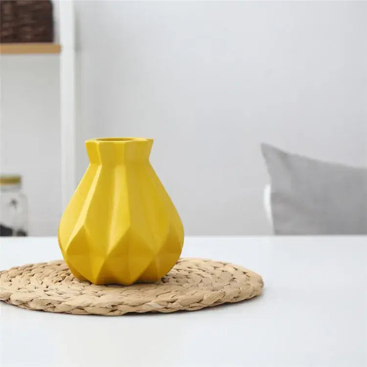A vibrant yellow decorbites ceramic diamond vase with a faceted geometric design for modern living room decor