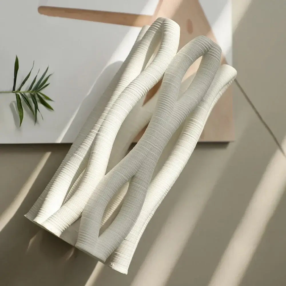 White ribbed silicone heat-resistant kitchen utensil with modern design complementing decorbites geometric ceramic spiral vase