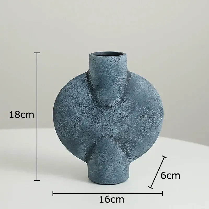 A matte blue geometric ceramic vase with textured asymmetrical design and rounded contours for decorbites geometric decor