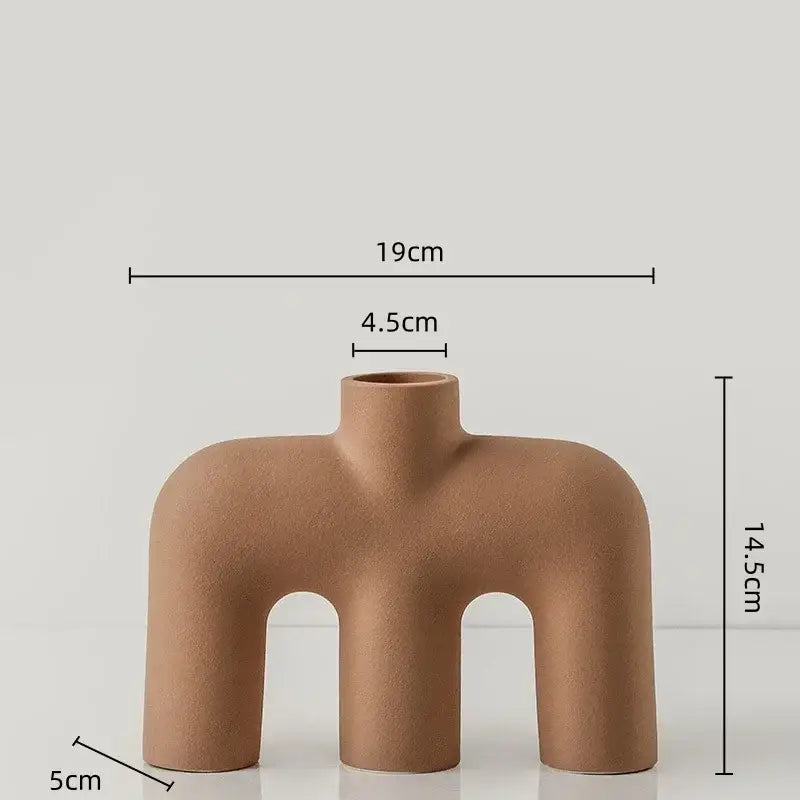 Tan geometric ceramic vase with modern abstract design featuring three curved legs and open top for living room decorbites geometric ceramic use