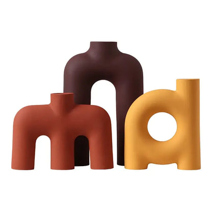 Three decorbites geometric ceramic vases in rust, deep brown, and mustard yellow with matte finish for living room decor