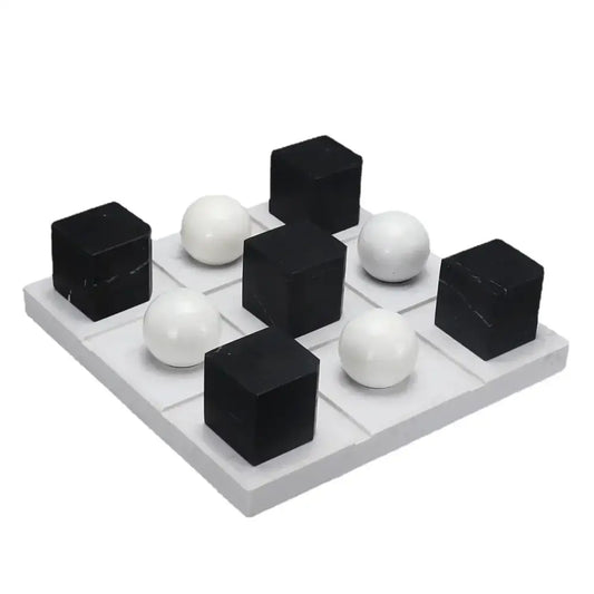 Modern geometric chess ornament set with black and white glossy cubes and spheres on gray grid base for home decor