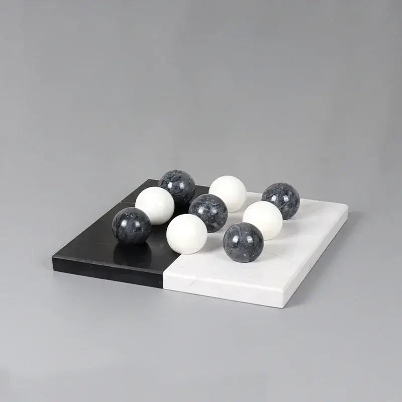 Modern geometric chess ornament set featuring black and white marble spheres on a dual-toned marble board for home decor