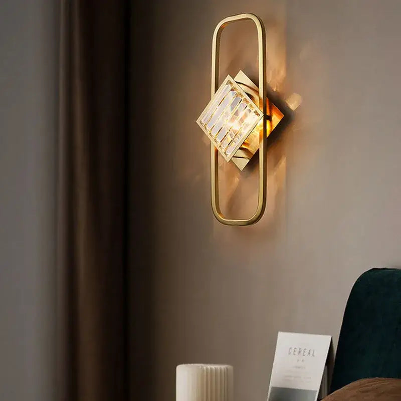 Modern geometric crystal gold wall lamp with gold-toned frame and faceted crystal accent for living room decorbites crystal gold